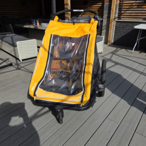 Yellow XLC Kids Trailer Duo S double child bicycle trailer with stroller handle and weather cover.